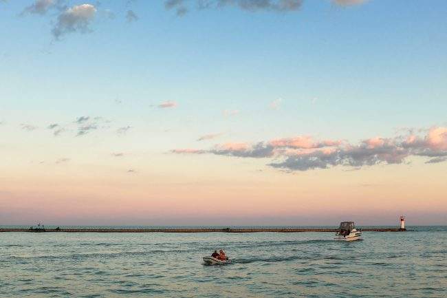 Two pleasure boats navigate the inner harbour on Lake Erie.