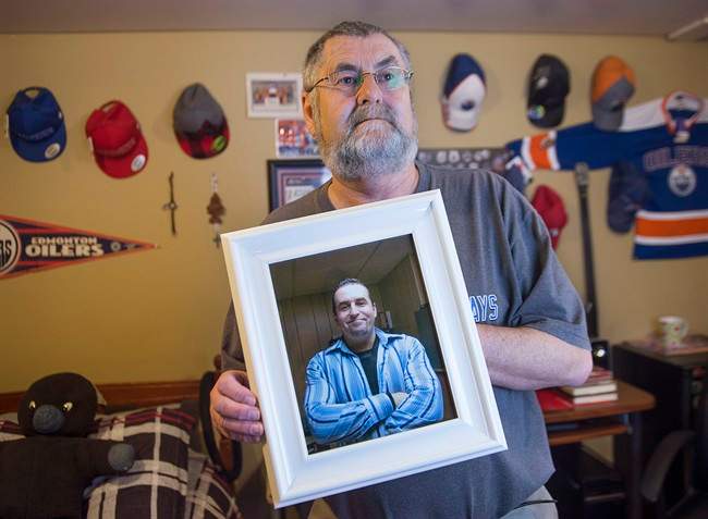 Ernie LeBlanc hold a photo of his son Jason LeBlanc at their home in Sydney Mines, N.s. on Monday, March 14, 2016.