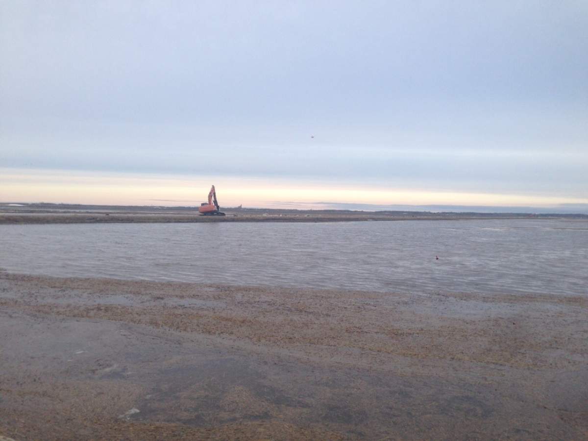 Crews work to drain water running over a road north of Niverville Wednesday morning. 