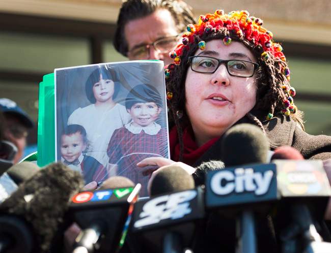 Jennifer Neville-Lake cries as she shows photographs of her three children who were killed in a horrific crash by drunk driver Marco Muzzo at the courthouse in Newmarket, Ont., on Tuesday, March 29, 2016.