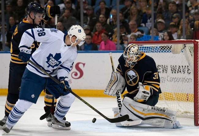 Toronto Maple Leafs center Colin Greening (38) deflects the puck as Buffalo Sabres goaltender Chad Johnson (31) and defenseman Rasmus Ristolainen, left, defend during the second period of an NHL hockey game, Thursday, March 31, 2016, in Buffalo, N.Y.