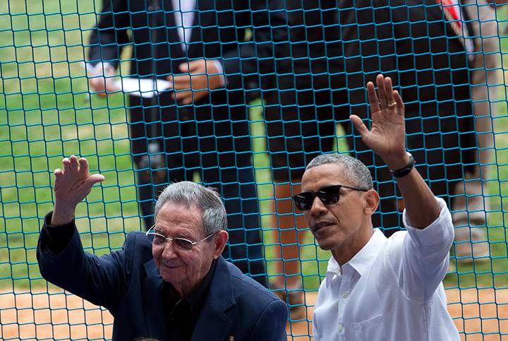 U.S. President Barack Obama, right, and his Cuban counterpart Raul Castro wave to cheering fans as they arrive for a baseball game between the Tampa Bay Rays and the Cuban national baseball team, in Havana, Cuba, Tuesday, March 22, 2016.