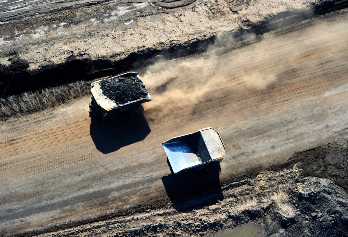 Huge Caterpillar 797 dump trucks working at the CNRL (Canadian Natural Resources Limited) Horizon oil sands mine near Fort McMurray, Alberta. 