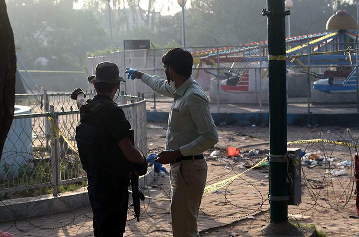 Pakistani security officials examine the cordoned-off site of the March 27 suicide bombing, in Lahore on March 28, 2016.