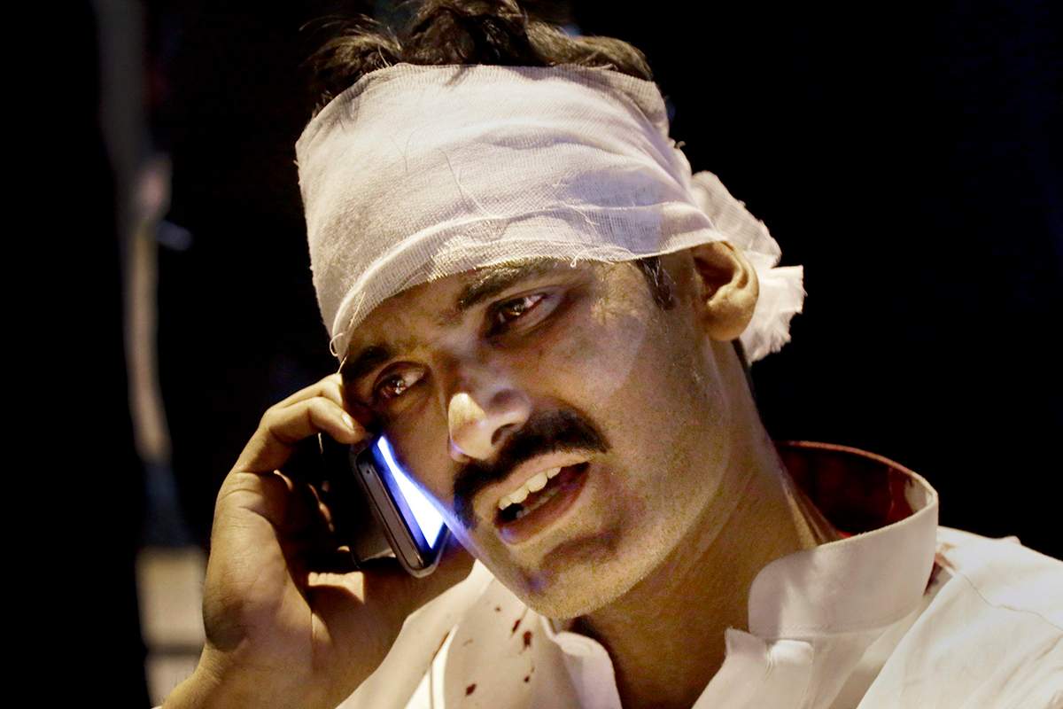 A Pakistani injured man from a bomb blast talks on his cell phone at a local hospital in Lahore, Pakistan, Sunday, March, 27, 2016.