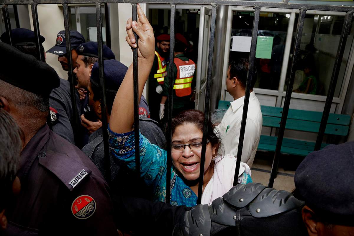 A woman weeps for her injured family members as she tries to speak to security at a local hospital in Lahore, Pakistan, Sunday, March, 27, 2016.