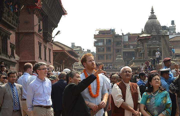 Prince Harry speaks with officials as he visits heritage sites in Patan Durbar Square on the outskirts of Kathmandu on March 20, 2016.