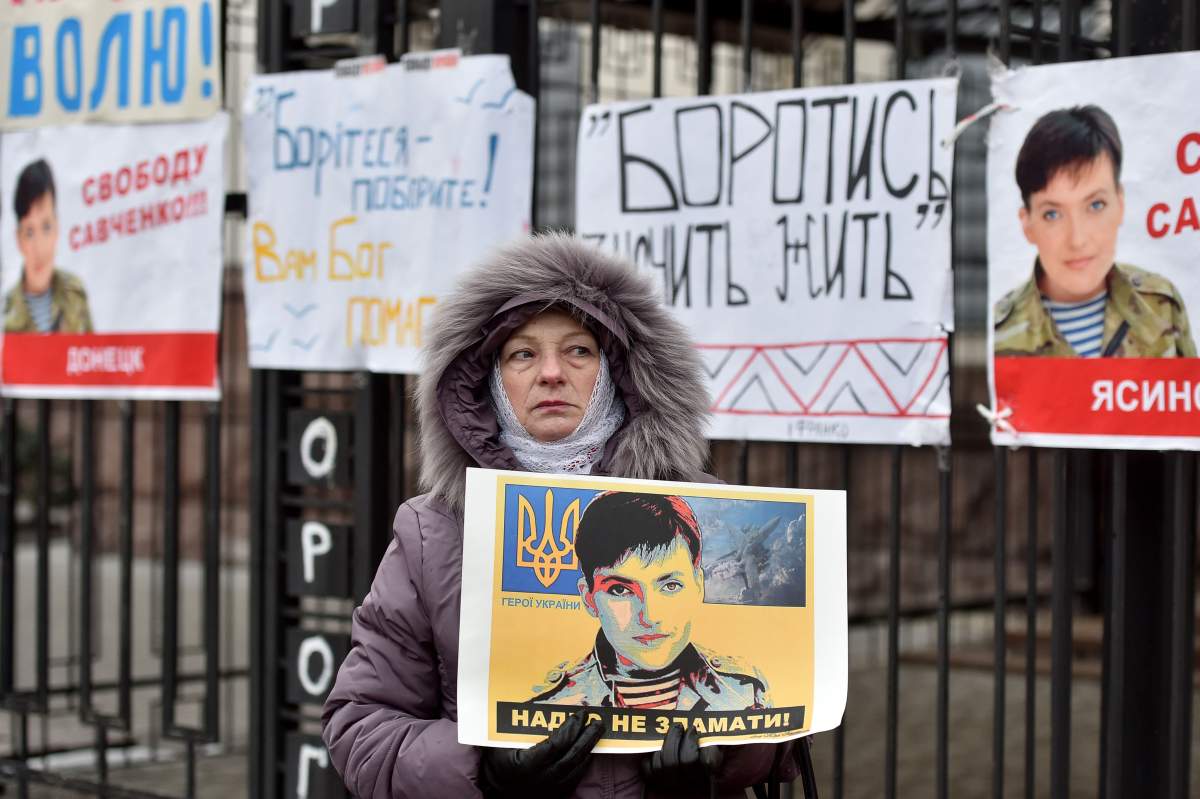 A woman holds a portrait of Ukrainian military pilot Nadiya Savchenko during a demonstration in front of the Russian embassy in Kiev on March 22, 2016.