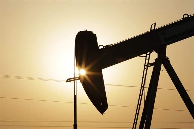 In this Wednesday, Sept. 30, 2015 file photo, an oil pump works at sunset in the desert oil fields of Sakhir, Bahrain.