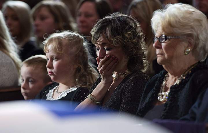 Former Toronto mayor Rob Ford’s widow, Renata, cries next to her husband’s casket, along with their children Stephanie and Dougie, and Ford’s mother Diane at St. James Cathedral in Toronto on Wednesday, March 30, 2016.