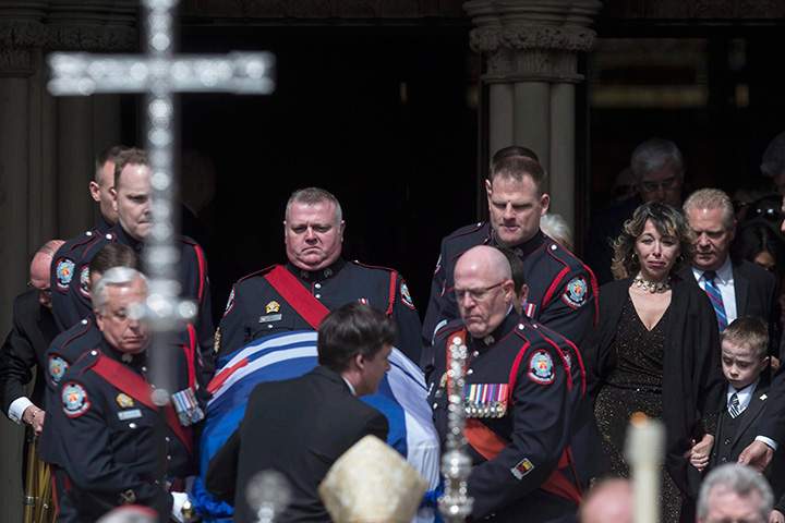 Rob Ford’s widow, Renata, holds her son Dougie’s hand as they follow her husband’s casket down the steps of Toronto’s St. James Cathedral following a funeral service, on Wednesday, March 30, 2016.