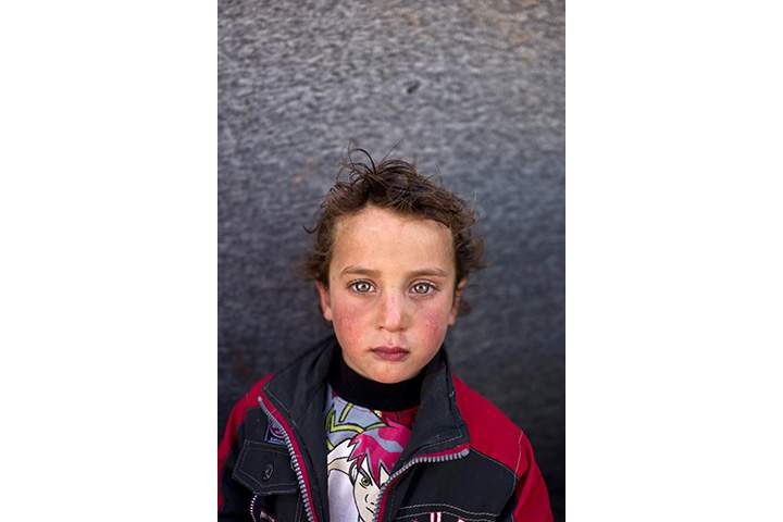 In this Monday, March 14, 2016 photo, Syrian refugee boy Hammad Khadir, 3, from Hassakeh, Syria, poses for a picture at an informal tented settlement near the Syrian border on the outskirts of Mafraq, Jordan.
