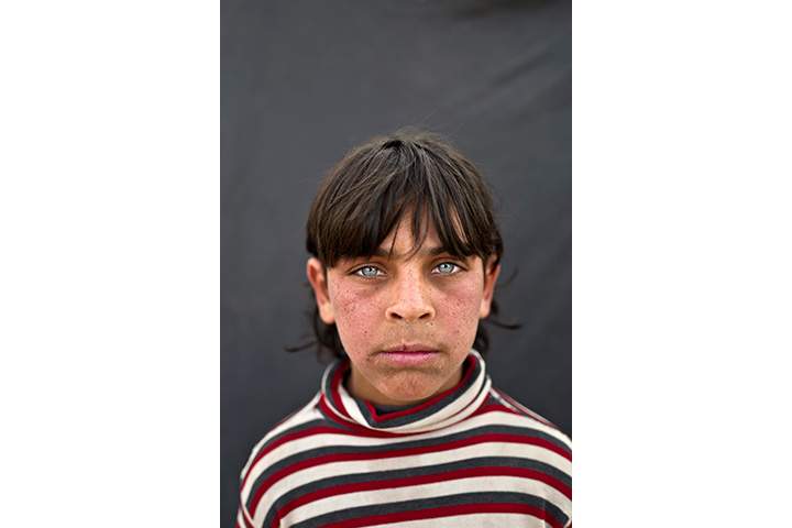 In this Saturday, March 12, 2016 photo, Syrian refugee boy Rakan Raslan, 11, from Hama, Syria, poses for a picture at an informal tented settlement near the Syrian border on the outskirts of Mafraq, Jordan.
