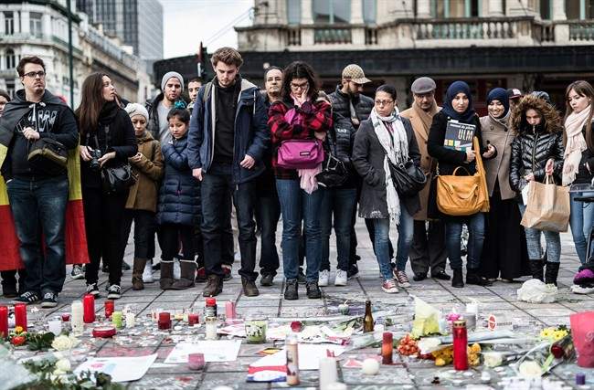 People gather at a memorial for victims of attacks in Brussels on Wednesday, March 23, 2016. Belgian authorities were searching Wednesday for a top suspect in the country\’s deadliest attacks in decades, as the European Union\’s capital awoke under guard and with limited public transport after scores were killed and injured in bombings on the Brussels airport and a subway station. (AP Photo/Valentin Bianchi)