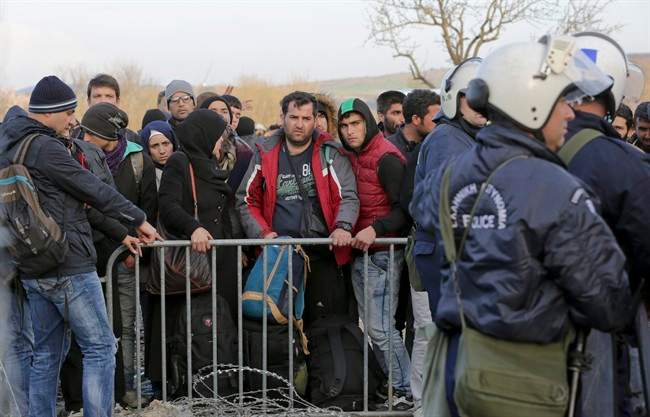 Stranded Syrian and Iraqi migrants wait to enter Macedonia from Greece near the southern Macedonian town of Gevgelija, Wednesday, March 2, 2016.