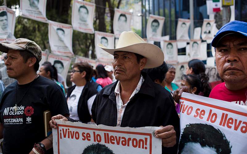 Relatives of 43 missing students from the Isidro Burgos rural teachers' college hold pictures of their missing loved ones after meeting with  Attorney General Arely Gomez Gonzalez in Mexico City, Thursday, March 17, 2016. 
