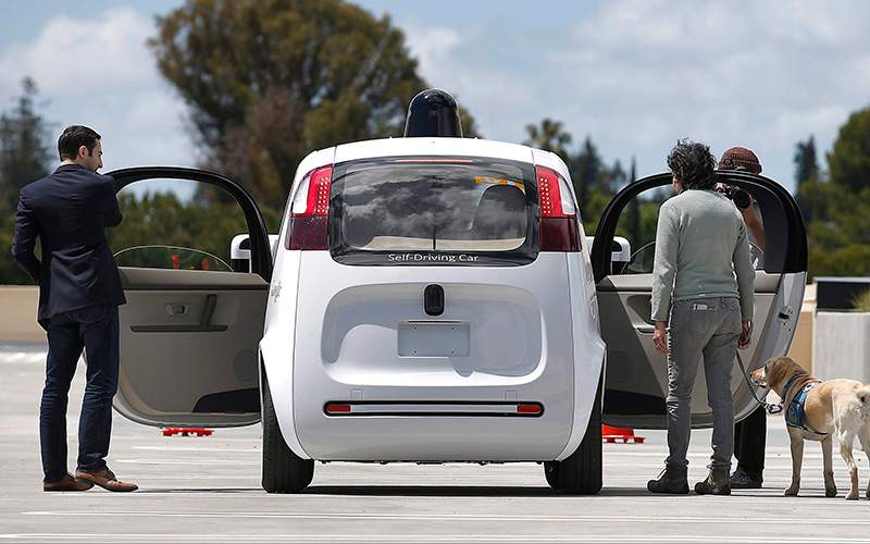 Riders enter the Google's new self-driving prototype car for a ride during a demonstration at Google campus on Wednesday, May 13, 2015, in Mountain View, Calif. 