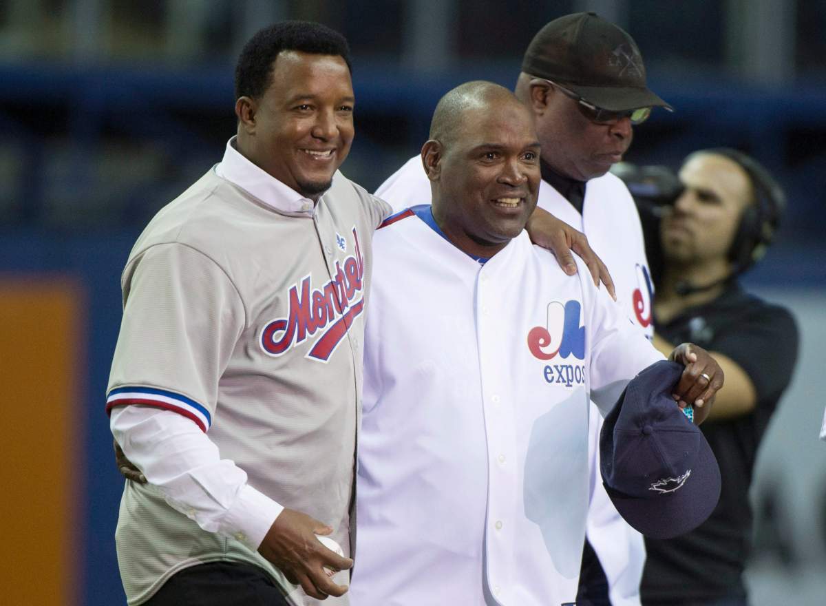 Former Montreal Expos pitcher Pedro Martinez, left, and outfielder Tim Raines share a laugh as they are honoured in a pre-game ceremony before the Toronto Blue Jays take on the Boston Red Sox in spring training baseball action Friday, April 1, 2016 in Montreal.