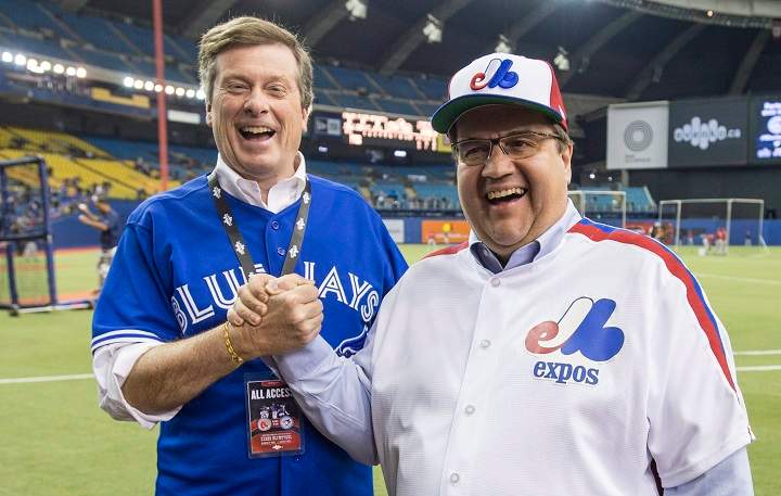 Montreal Mayor Denis Coderre, right, shares a laugh with Toronto counterpart John Tory prior to the Blue Jays facing the Boston Red Sox in a spring training baseball game Saturday, April 2, 2016 in Montreal.