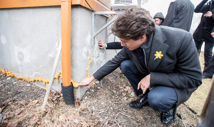 Prime Minister Justin Trudeau looks at the foundation of a house weakened by pyrite, Wednesday, April 6, 2016 in Trois-Rivieres, Que.