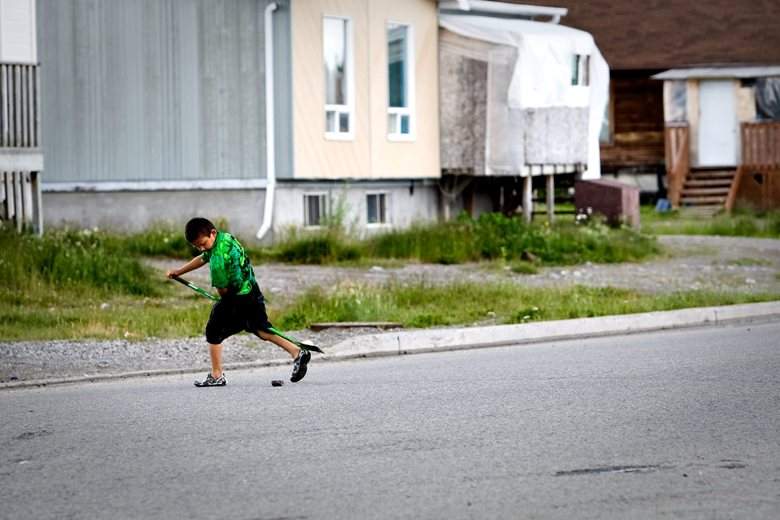 A young First Nations child plays street hockey, July 17, 2009.