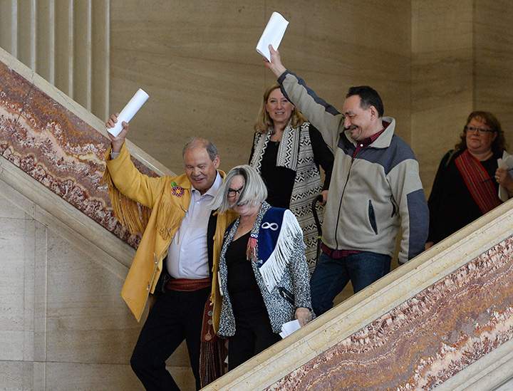 Bruce Dumont, president of the BC Metis Nation, left, Audrey Poitras, president of the Alberta Metis Nation, front, and Gerald Morin, vice president of the Saskatchewan Metis Nation, right, celebrate after a decision at the Supreme Court of Canada in Ottawa on Thursday, April 14, 2016.