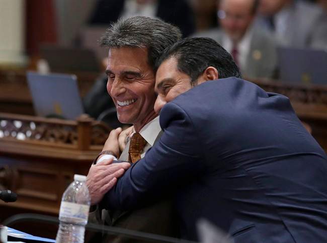 State Sen. Mark Leno, D-San Francisco, left, one of the authors of a bill to raise California's minimum wage, is hugged by Sen. Ben Hueso, D-San Diego, as the Senate voted on the bill, Thursday, March 31, 2016, in Sacramento, Calif. (AP Photo/Rich Pedroncelli).