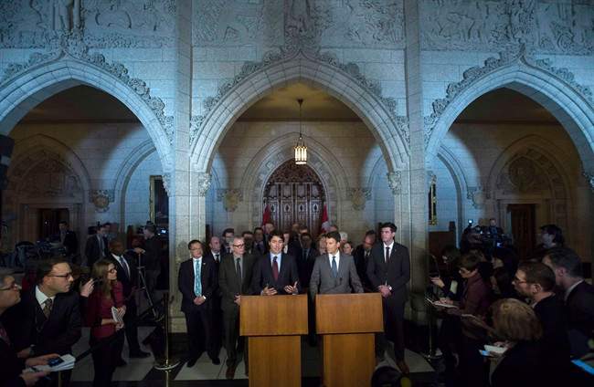 Surrounded by mayors and journalists Prime Minister Justin Trudeau and Vancouver Mayor Gregor Robertson take part in a news conference in the Foyer of the House of Commons on Parliament Hill in Ottawa on February 5, 2016. Providing infrastructure and services without adequate financial tools has been a major stress for municipalities of all sizes, and that's not the only obstacle they face, says Port Coquitlam Greg Moore. Mayors have used the change in the federal government to call for more autonomy for cities, which are straining under the weight of downloaded responsibilities from rental housing to daycare. Earlier this year, big-city mayors met with Prime Minister Justin Trudeau and urged Ottawa to directly fund building projects, bypassing the provinces altogether.