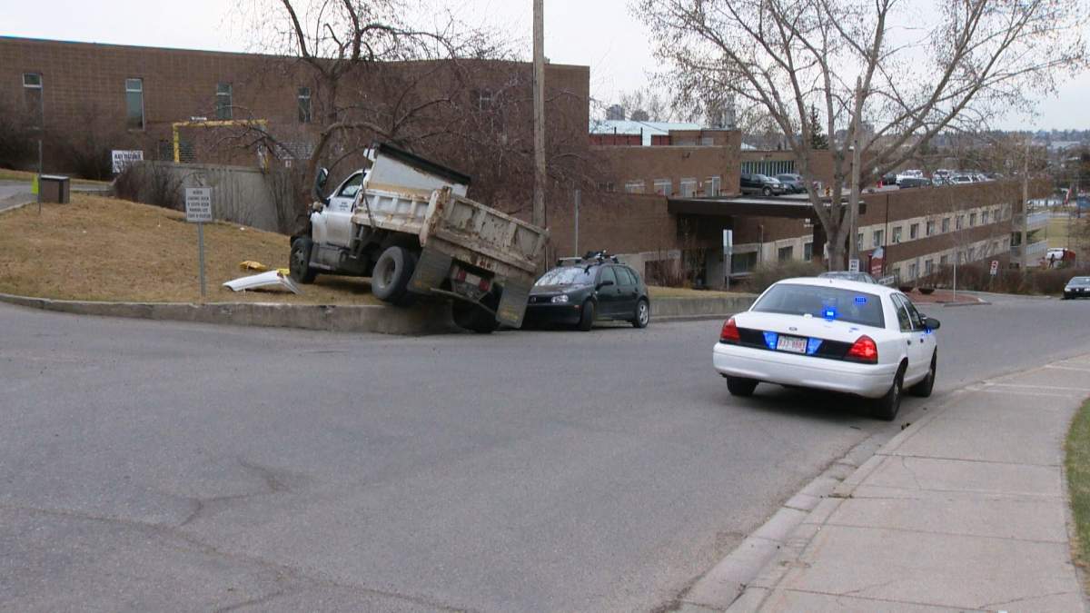 A dump truck collided with a fire hydrant and tree before coming to rest on a retaining wall in northwest Calgary on Monday, April 4, 2016.