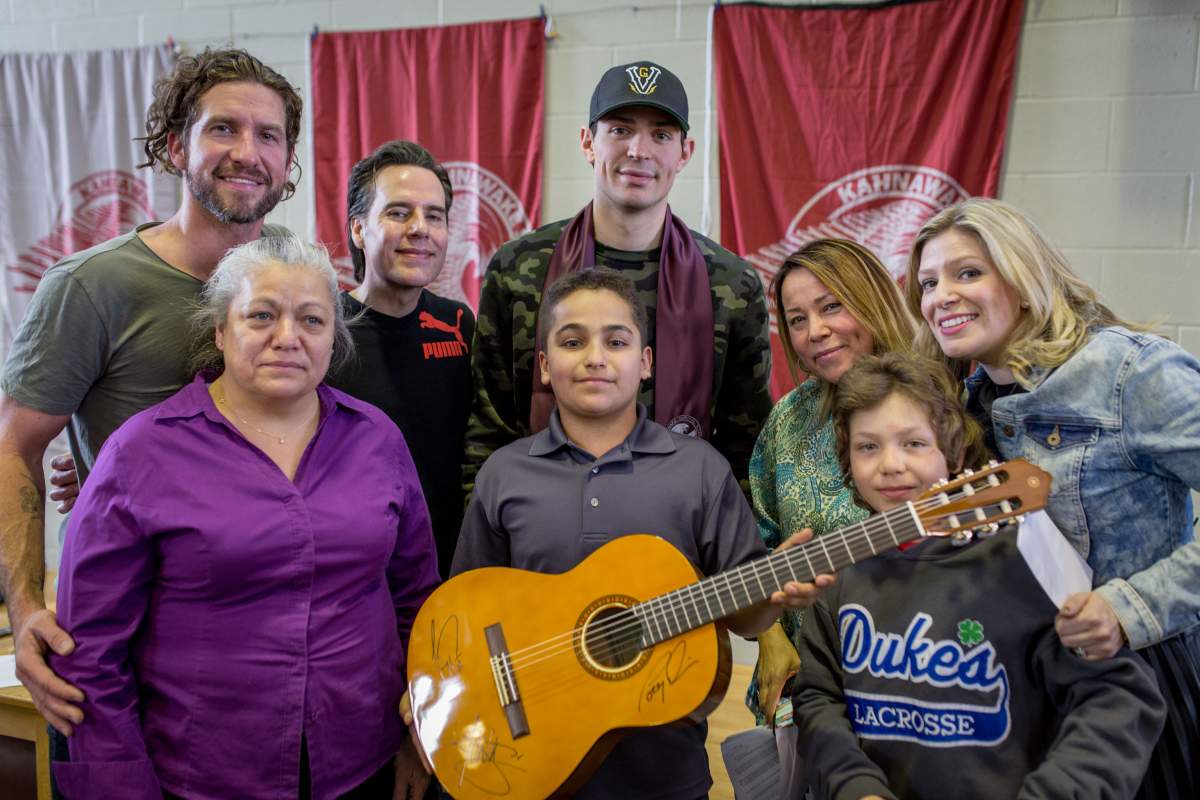 Singer Jonas, guitarist Corey Diabo, Montreal Canadiens goalie Carey Price and host Anne-Marie Withenshaw pose for a picture with students and teachers at Kahnawake Survival School, Wednesday, March 23, 2016.