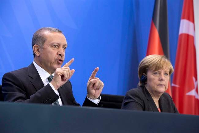 Turkish President Tayyip Recep Erdoğan (then prime minister) sits next to German Chancellor Angela Merkel at a 2014 joint press conference in Berlin. Germany is considering a request from Turkey to prosecute a TV comedian who wrote a crude poem about the Turkish president.