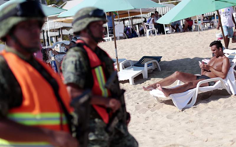 Mexican soldiers patrol a beach at the Bay of Santa Lucia in Acapulco, Guerrero state, Mexico after an increase of violence in the tourist area of this sea resort, on March 4, 2016. The country endured 10 years of drug violence that has left 100,000 people dead or missing.   