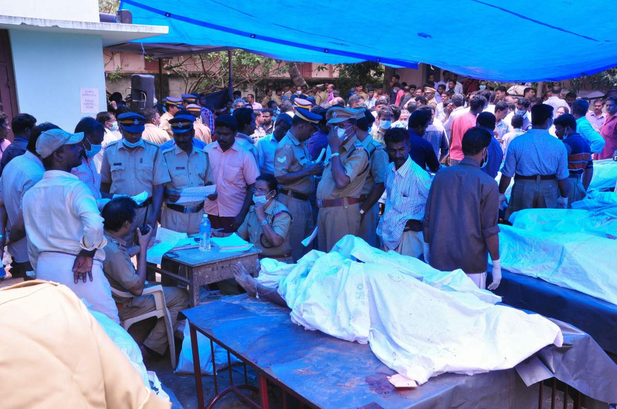 Indian officals stand next to bodies kept outside of a hospital as relatives try to identify victims of a huge fire at the Puttingal Devi Temple in Paravur on April 10, 2016.A massive fire swept through a temple in the southern Indian state of Kerala on April 10, killing more than 100 people and injuring at least 280 after thousands gathered to watch a fireworks display./ AFP / – (Photo credit should read -/AFP/Getty Images)