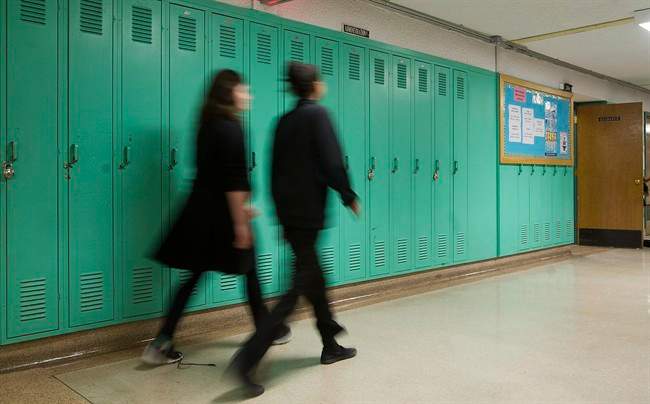 Students walk by lockers in a Montreal school.