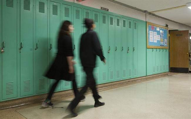 Students walk by lockers at Lakeside Academy school in the Montreal borough of Lachine, Friday, April 1. 2016.
