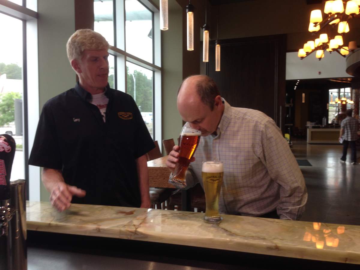 Ted field checks out the suds at Central City Brewery in Surrey as Gary Lohin supervises.