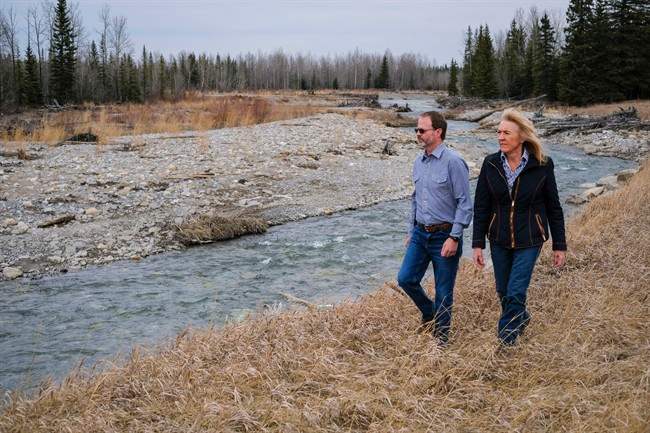 Lee Drewry, left, and Mary Robinson walk along the Elbow River where a reservoir will be if government plans go ahead, near Bragg Creek, Alta., Friday, April 8, 2016.