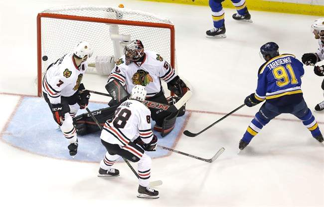 St. Louis Blues' Vladimir Tarasenko (91), of Russia, watches as a puck slips past Chicago Blackhawks goalie Corey Crawford, Brent Seabrook (7) and Patrick Kane (88) during the first period in Game 7 of an NHL hockey first-round Stanley Cup playoff series Monday, April 25, 2016, in St. Louis.