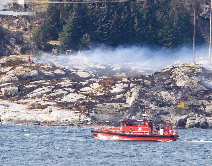A search and rescue vessel patrols off the coast of the island of Turoey, near Bergen, Norway, as emergency workers attend the scene after a helicopter crashed believed to have 13 people aboard, Friday April 29, 2016.