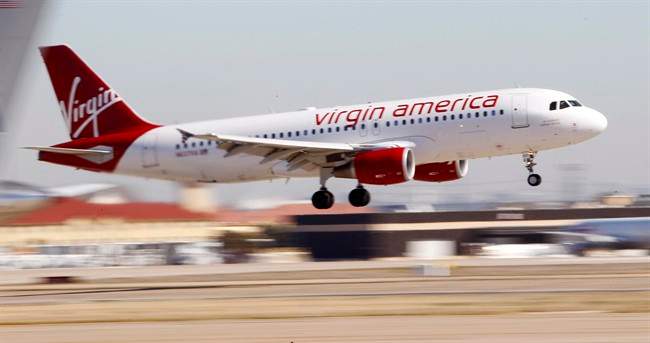 In this Dec. 1, 2010, file photo, Virgin America’s inaugural flight between Los Angeles and Dallas Fort Worth International Airport comes in for a landing in Grapevine, Texas.