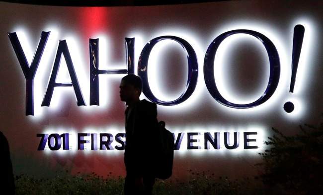 In this Nov. 5, 2014, file photo a person walks in front of a Yahoo sign at the company's headquarters in Sunnyvale, Calif.