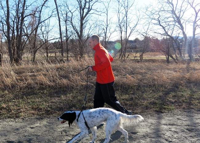 Veterinarian Jeff Gerlesits runs with his dog, Dawson, an English setter, on a train in Arvada, Colo.