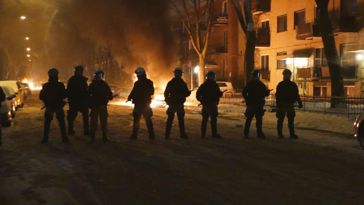 Riot police stand still in the middle of chaos, Wednesday, April 6, 2016.