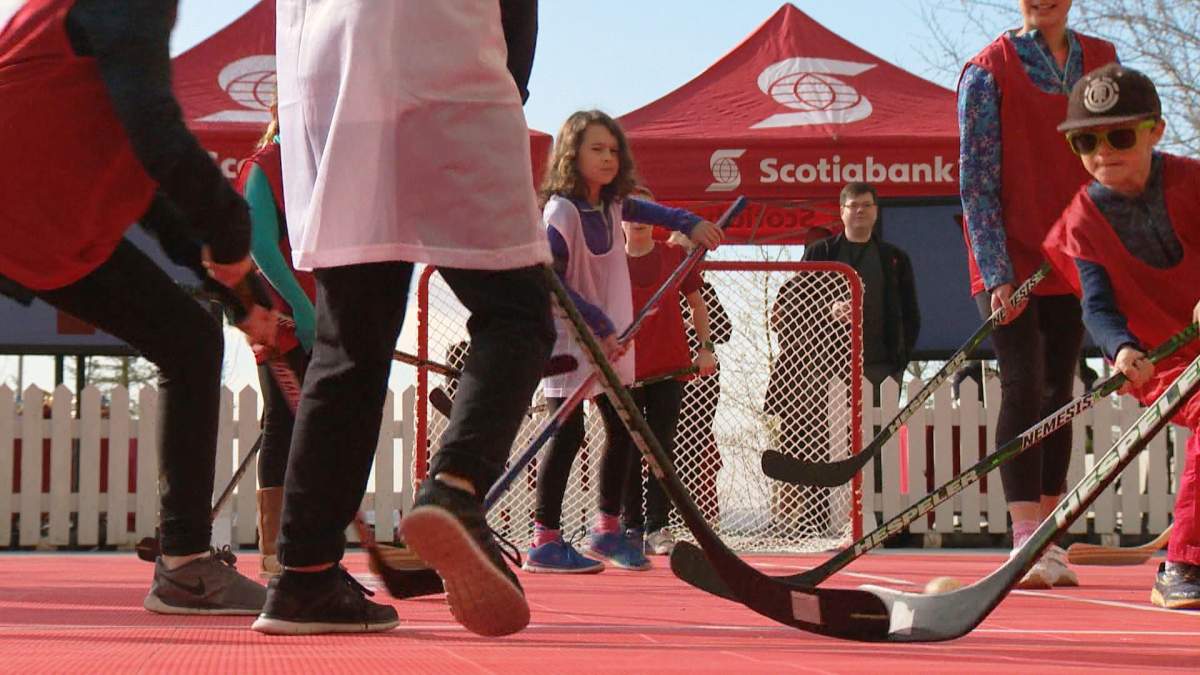 Kids play hockey on an outdoor sports pad at the South Health Campus YMCA. 