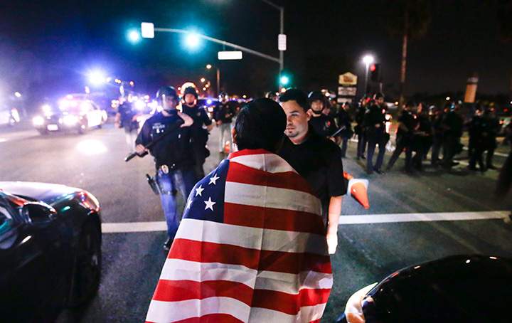 Protestors are pushed off the street by law enforcement after a rally for Republican presidential candidate Donald Trump, Thursday, April 28, 2016 in Costa Mesa, Calif.