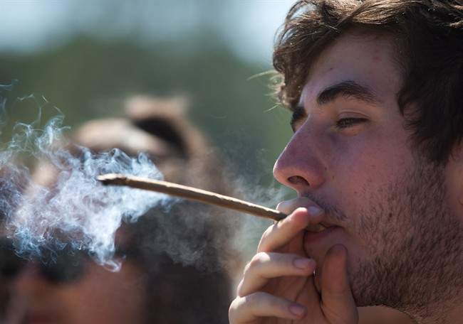 FILE PHOTO: A man smokes during the annual 4/20 cannabis culture celebration at Sunset Beach in Vancouver, B.C.