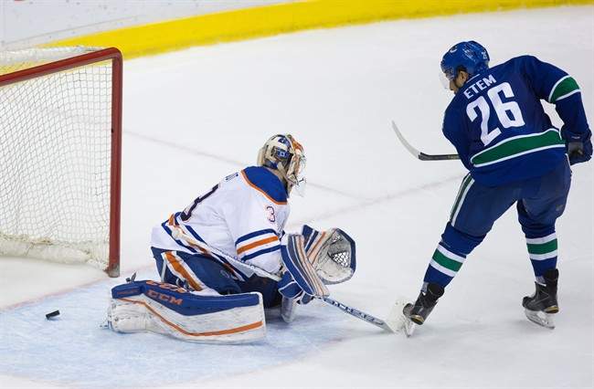 Vancouver Canucks' Emerson Etem, right, scores the winning goal against Edmonton Oilers goalie Cam Talbot during an overtime shootout during an NHL hockey game in Vancouver, B.C., on Saturday April 9, 2016.