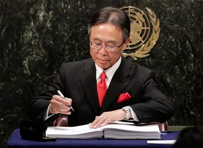 Motohide Yoshikawa, Japan's United Nations Ambassador, signs the Paris Agreement on climate change, Friday, April 22, 2016 at U.N. headquarters. (AP Photo/Mark Lennihan).