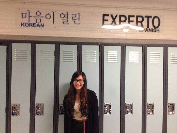 Patricia Panganiban standing below signs in the hallway