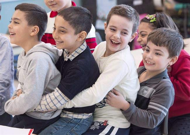 In this 2016 file photo, Syrian refugees Jamil Haddad (left to right), Tony Batekh, George Louka and Edmon Artin have some fun while they attend French classes at a school. Immigration has been a hot-button issue in the Quebec provincial election. Sunday, Sept. 23, 2018.
